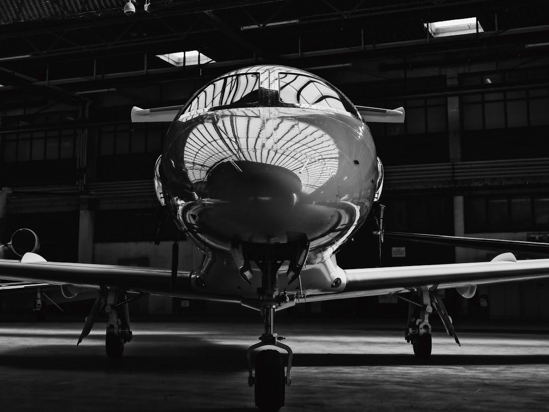 Frontvy av ett mindre flygplan i en mörk flyghangar