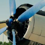 Närbild av ett äldre propellerflygplans blå propeller och motor