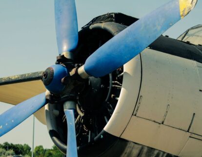 Närbild av ett äldre propellerflygplans blå propeller och motor