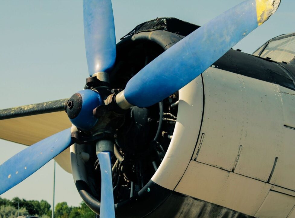 Närbild av ett äldre propellerflygplans blå propeller och motor