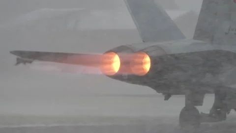 Jetflygplan med två lysande efterbrännare i kraftigt regn